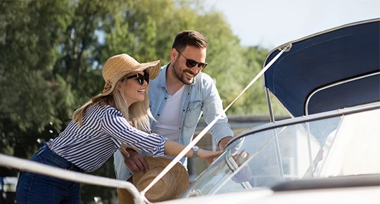 Couple looking over a boat by the water
